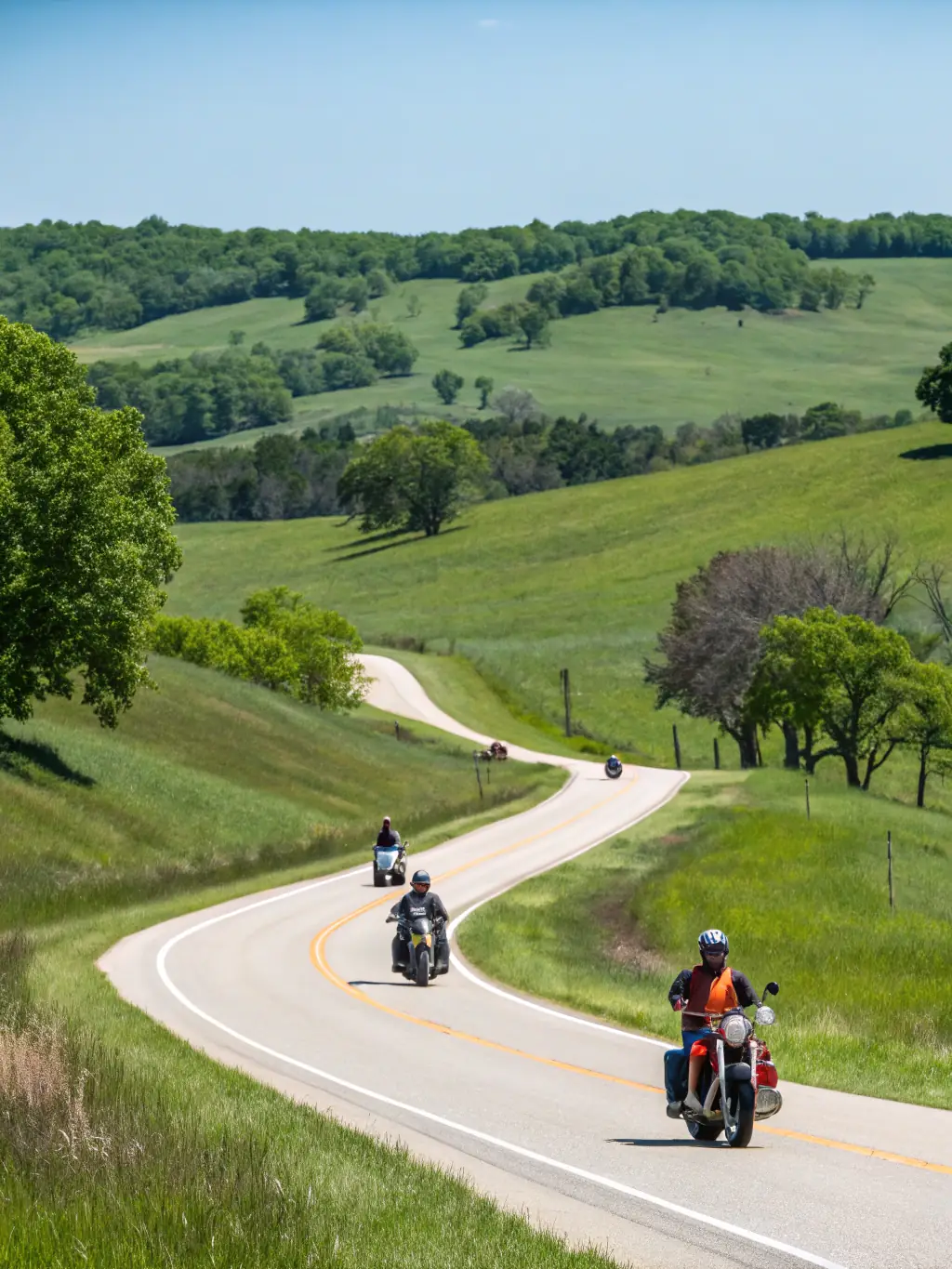 A high-angle shot of a motorcycle escort team leading a group of riders through a scenic route in the Thiérache region, showcasing their expertise and professionalism.